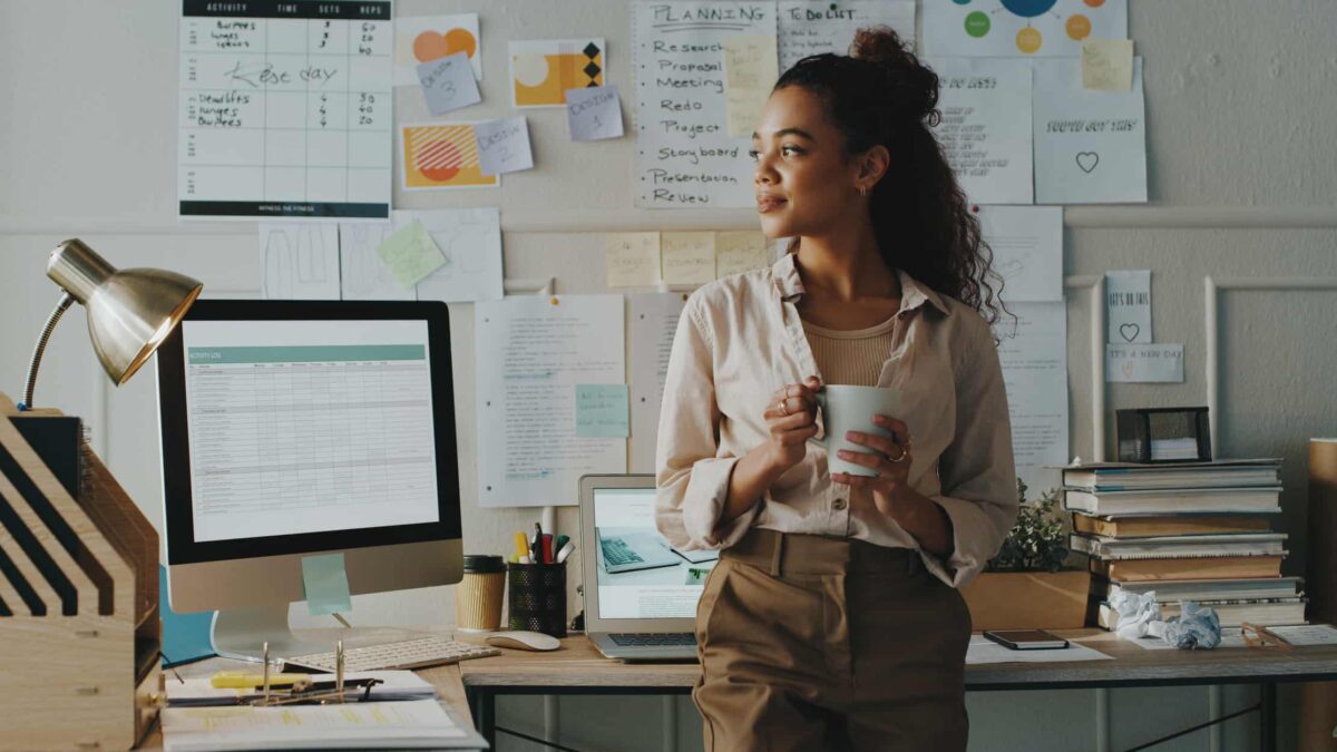 A worker drinks out of a mug in an office.