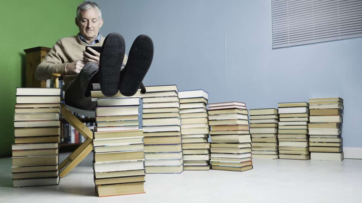 a man relaxes with his feet on a pile of books