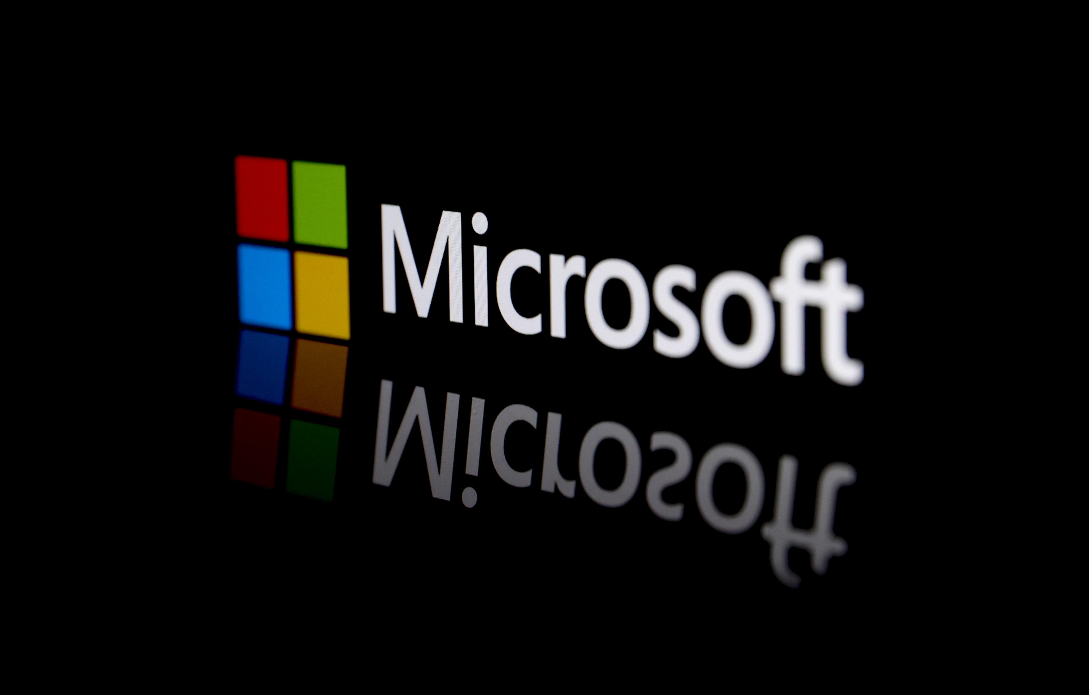 The Microsoft logo is reflecting from a digital screen onto a stage. 