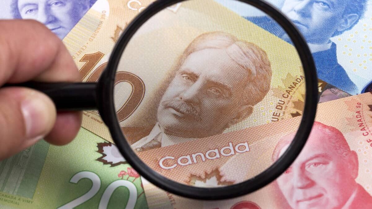 Canadian dollars in a magnifying glass